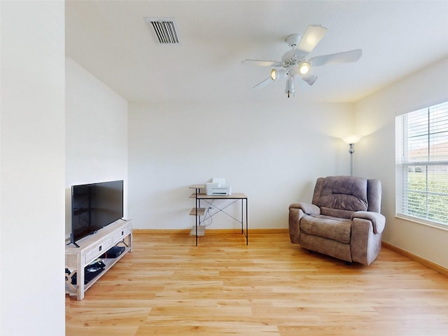 living area featuring light wood-type flooring and ceiling fan