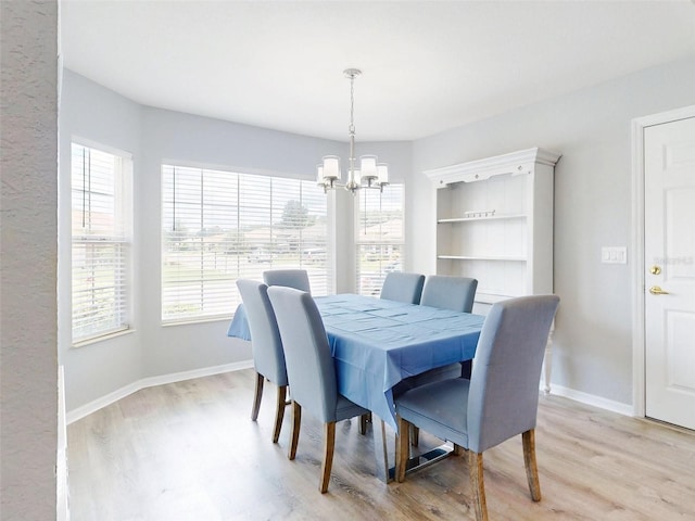 dining space featuring light hardwood / wood-style flooring and an inviting chandelier