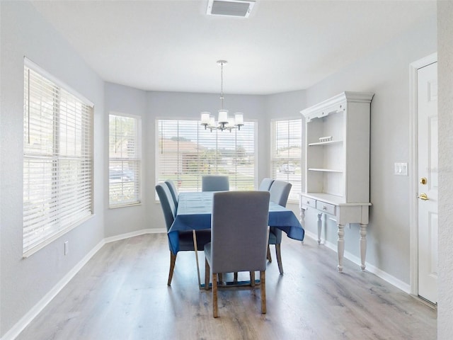 dining area featuring a notable chandelier and light hardwood / wood-style flooring