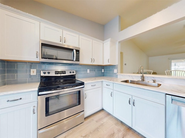 kitchen featuring light wood-type flooring, stainless steel appliances, white cabinetry, and sink