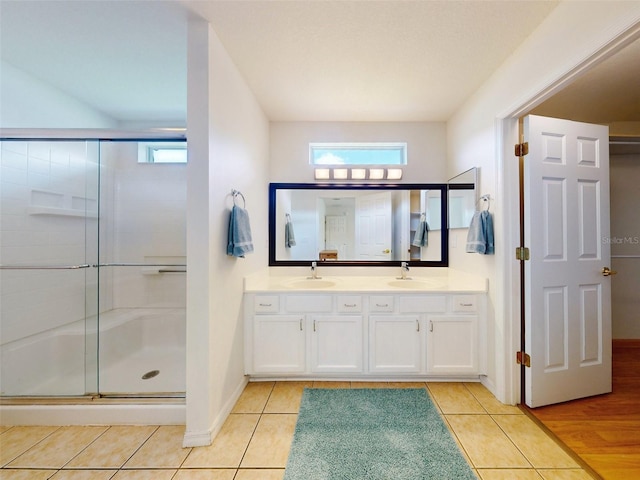 bathroom with tile patterned floors, a shower with door, and vanity