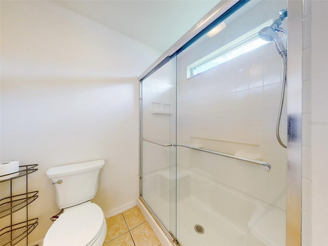 bathroom with tile patterned flooring, toilet, and a shower with door