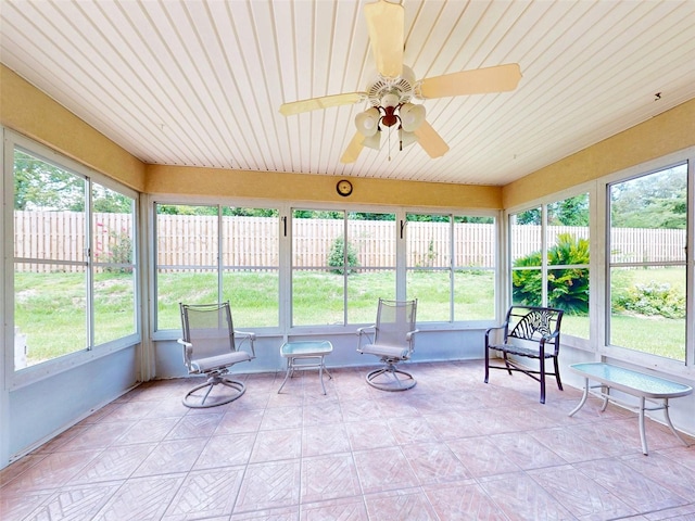 unfurnished sunroom featuring ceiling fan and a healthy amount of sunlight