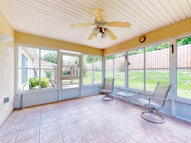 unfurnished sunroom with plenty of natural light and ceiling fan