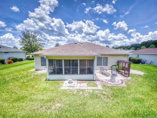 rear view of house featuring a sunroom, a patio, and a lawn