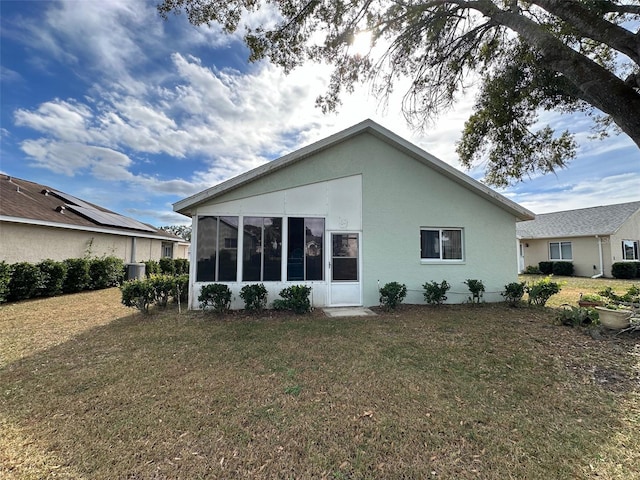 rear view of property with a sunroom and a yard