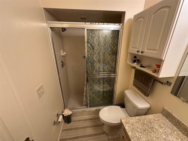 bathroom with tile patterned floors, vanity, toilet, and walk in shower