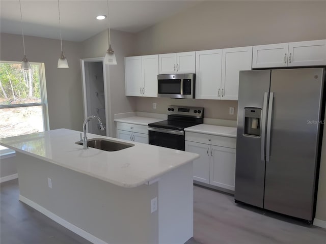 kitchen featuring white cabinets, appliances with stainless steel finishes, a kitchen island with sink, and sink