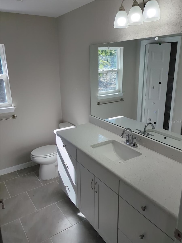 bathroom with tile patterned flooring, vanity, and toilet