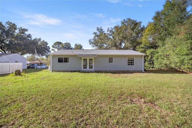 rear view of property featuring a lawn and french doors