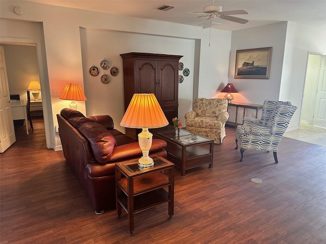 living room with ceiling fan and dark wood-type flooring