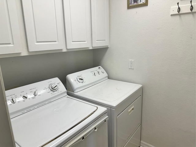 washroom featuring washing machine and clothes dryer and cabinets