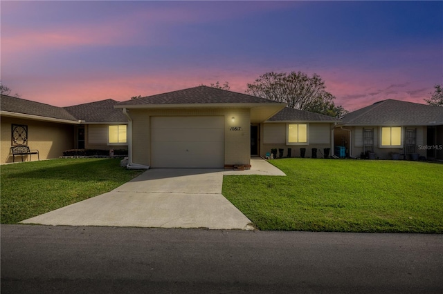 single story home featuring a yard and a garage