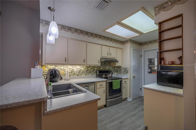 kitchen featuring sink, hanging light fixtures, kitchen peninsula, light hardwood / wood-style floors, and appliances with stainless steel finishes