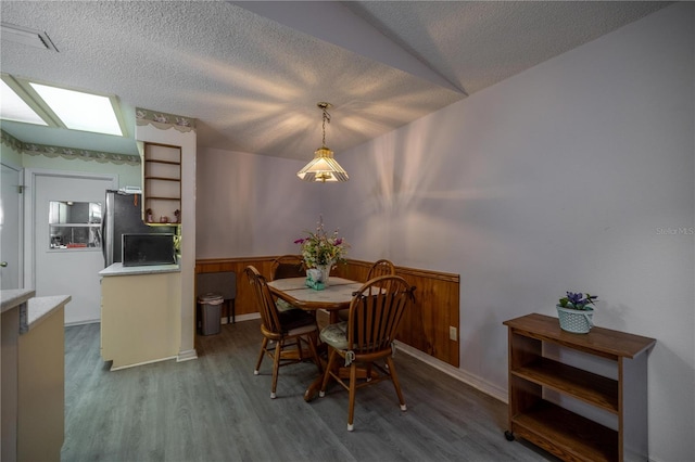 dining space with wood-type flooring and a textured ceiling