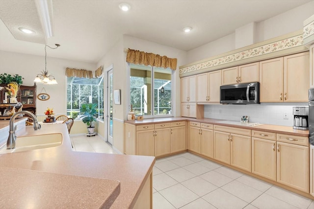 kitchen featuring sink, light brown cabinets, decorative light fixtures, an inviting chandelier, and light tile patterned flooring