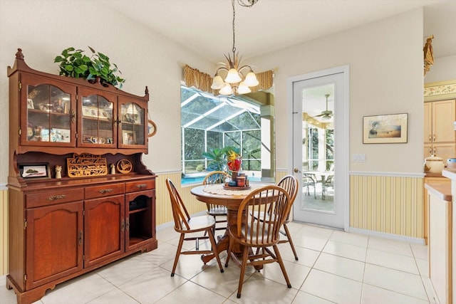 tiled dining area featuring ceiling fan with notable chandelier