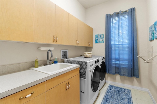 laundry area featuring washing machine and clothes dryer, tile patterned flooring, cabinets, and sink