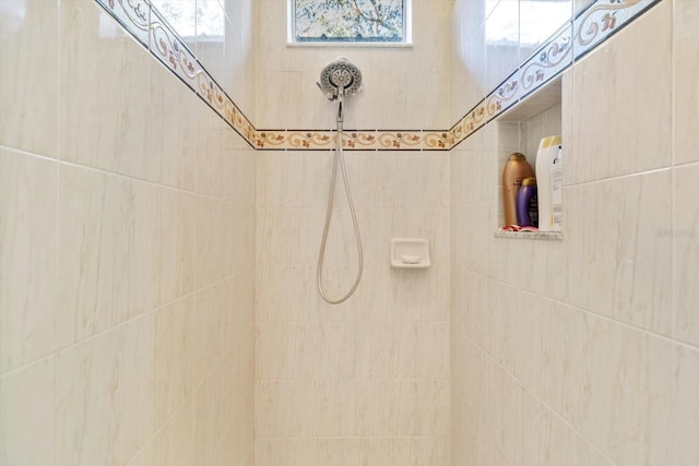 bathroom featuring a tile shower and a wealth of natural light