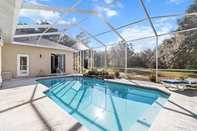 view of pool featuring glass enclosure and a patio