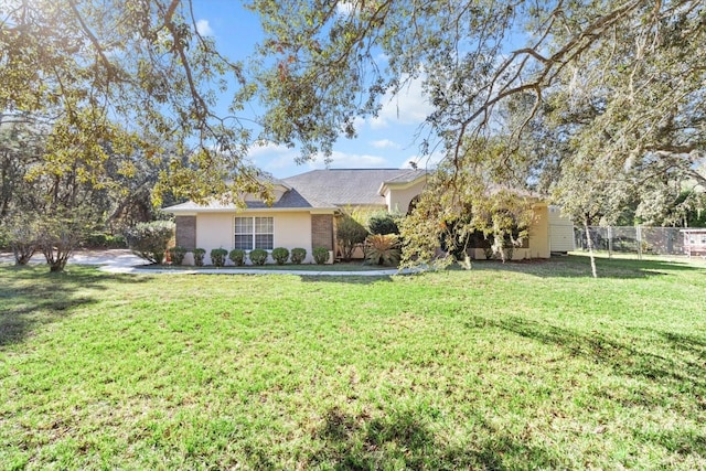 ranch-style home featuring a front lawn