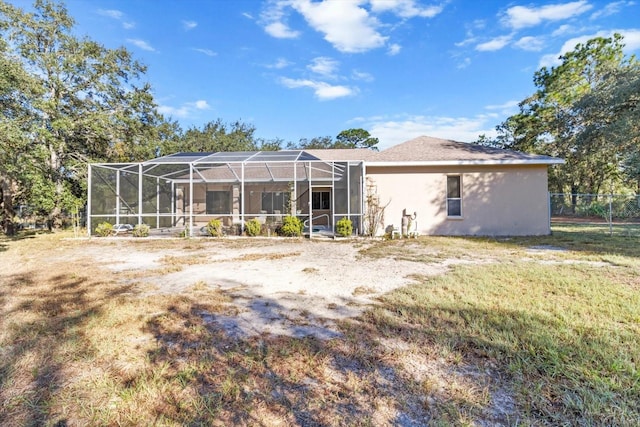 back of property featuring a lanai and a yard