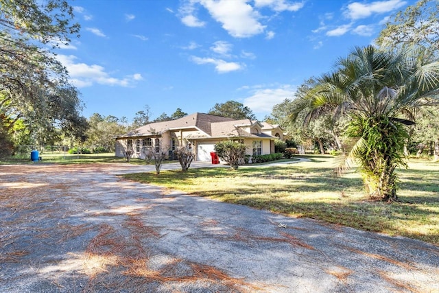 ranch-style house featuring a garage and a front lawn