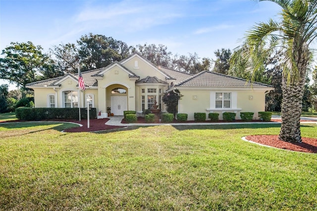 mediterranean / spanish home with a front lawn