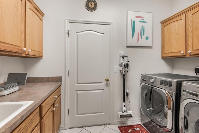 clothes washing area featuring sink, light tile patterned flooring, cabinets, and independent washer and dryer