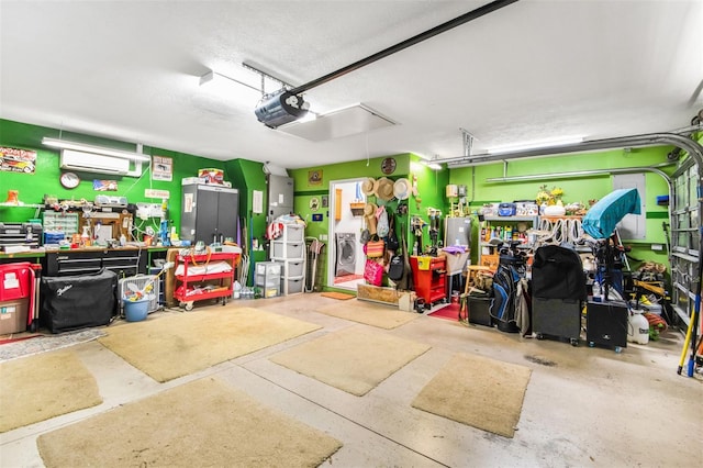 garage with a workshop area, a garage door opener, and an AC wall unit