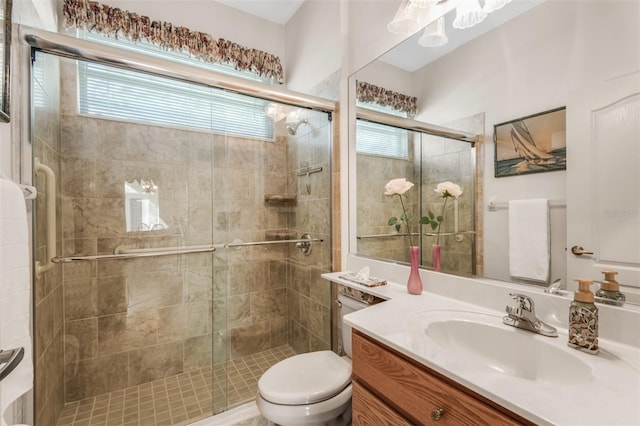 bathroom with vanity, toilet, and a shower with door