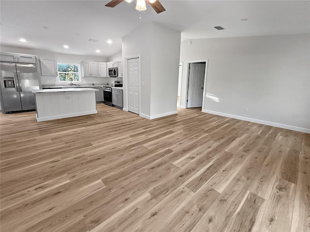 unfurnished living room with ceiling fan, light hardwood / wood-style flooring, high vaulted ceiling, and sink