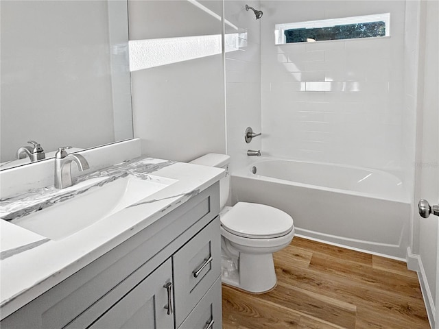 full bathroom featuring toilet, hardwood / wood-style floors, vanity, and tiled shower / bath