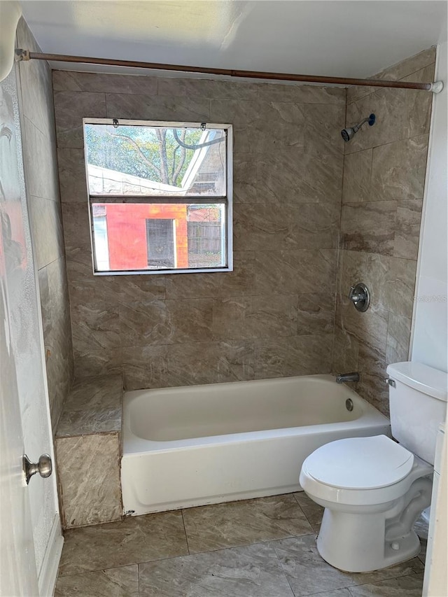 bathroom with tiled shower / bath and toilet