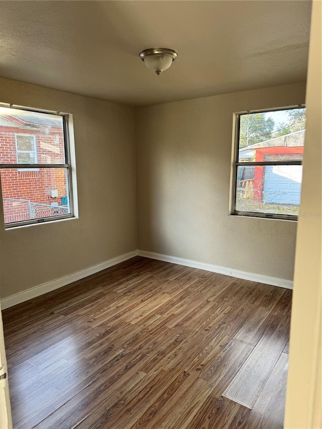 empty room with dark hardwood / wood-style floors