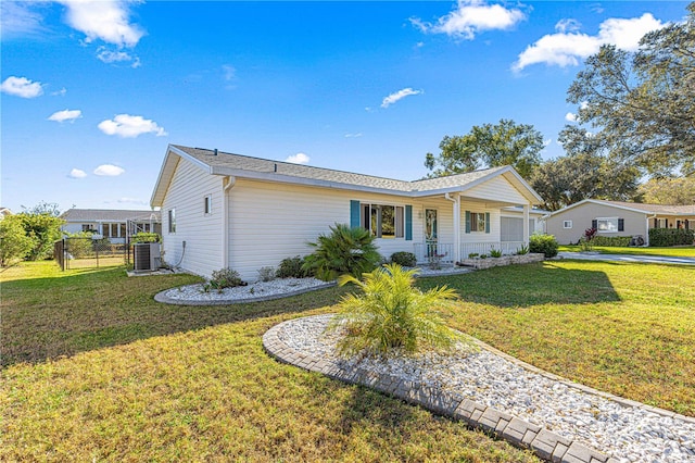 ranch-style home featuring covered porch, central air condition unit, and a front yard