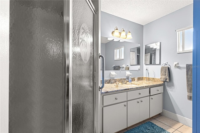 bathroom featuring vanity, a textured ceiling, tile patterned floors, and a wealth of natural light