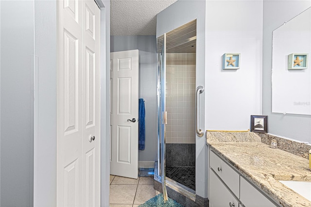 bathroom with tile patterned flooring, a textured ceiling, vanity, and an enclosed shower