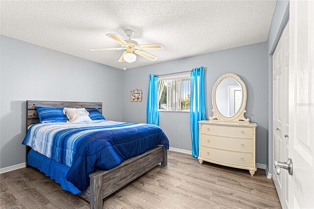 bedroom with hardwood / wood-style floors, a textured ceiling, a closet, and ceiling fan