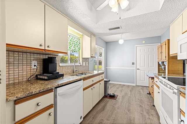 kitchen with white appliances, sink, a textured ceiling, tasteful backsplash, and white cabinetry