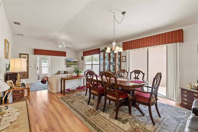 dining room featuring light hardwood / wood-style flooring, ceiling fan with notable chandelier, and lofted ceiling