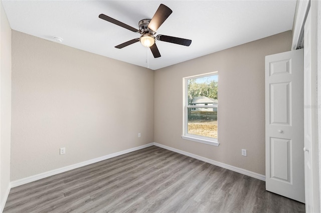 spare room featuring light wood-style floors, ceiling fan, and baseboards