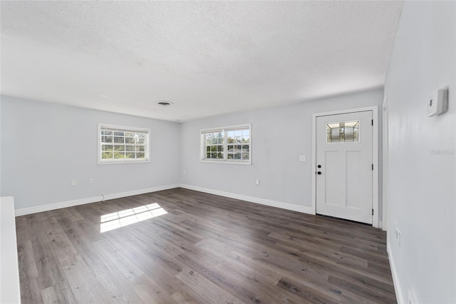 foyer with a textured ceiling and dark wood-type flooring