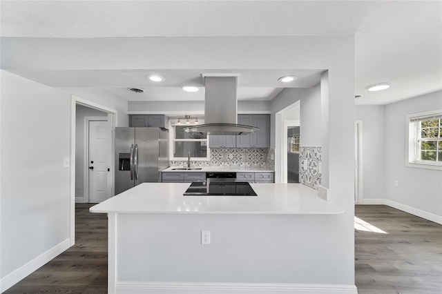 kitchen featuring gray cabinetry, island range hood, dark hardwood / wood-style flooring, and stainless steel refrigerator with ice dispenser