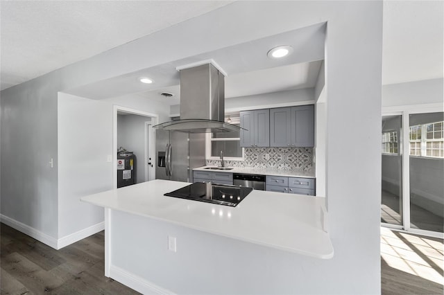 kitchen with sink, stainless steel appliances, dark wood-type flooring, electric water heater, and island exhaust hood