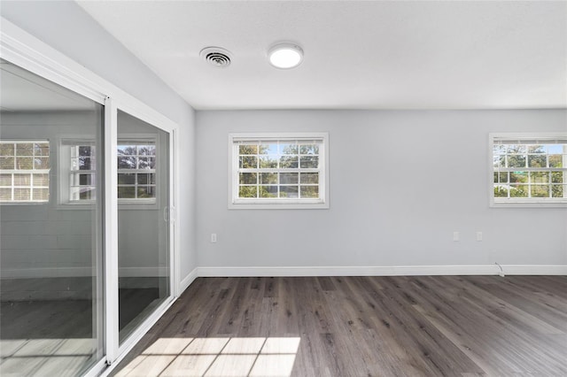 empty room featuring dark hardwood / wood-style floors and a healthy amount of sunlight