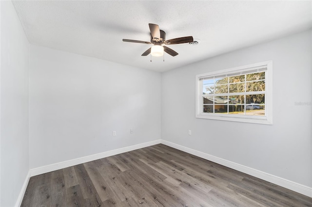 unfurnished room featuring a textured ceiling, dark hardwood / wood-style flooring, and ceiling fan