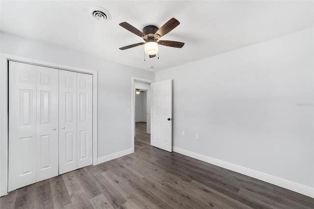 unfurnished bedroom featuring ceiling fan, a closet, and dark hardwood / wood-style floors