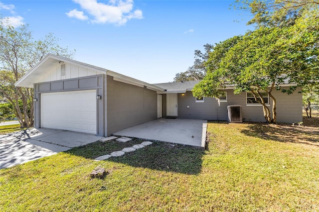 ranch-style house with central air condition unit, a front yard, and a garage