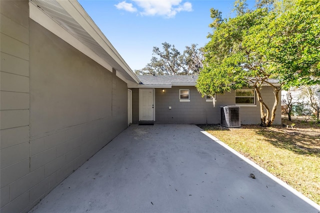 view of exterior entry with cooling unit and a patio area